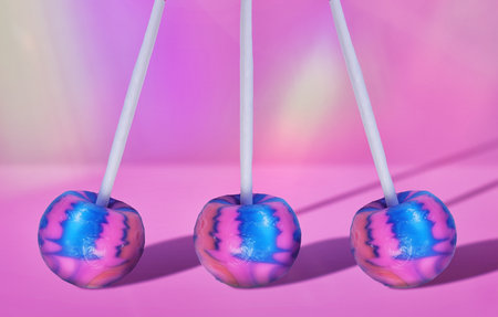 Surreal Sweet Treats - Electric Blue and Hot Pink Lollipop Candy on Pastel Background for Unique Dessert Conceptsの写真素材