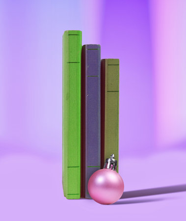 Purple Toned Holiday Composition with Christmas Ornament and Vertical Books  Cozy Reading Concept Photoの写真素材