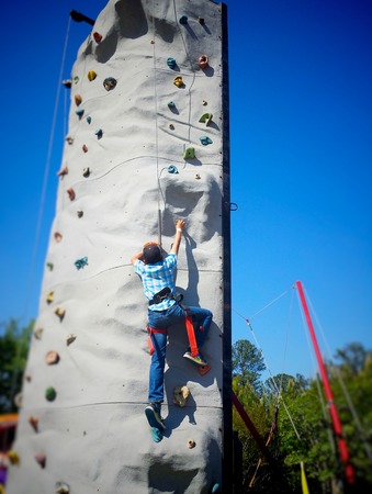 A boy climbing a wallの写真素材