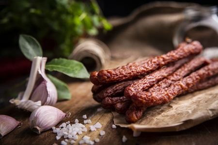 Smoked sausage, a composition of traditional dry, thin rural meats on a dark background. Regional food.の写真素材