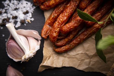 Smoked sausage, a composition of traditional dry, thin rural meats on a dark background. Regional food.の写真素材