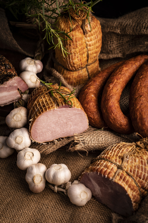 Smoked pork ham, bacon and sausage. A homemade composition of cold meats.Vertical compositionの写真素材