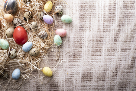Easter composition, colorful eggs on a linen natural background, composition with space for textの写真素材