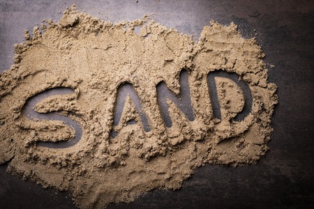 Sandy background with the word sand. Sand, beach, horizontal compositionの写真素材