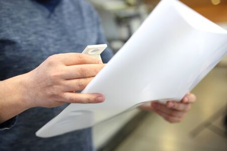 Sheet print control. A man in a printing house on the background of the machineの写真素材