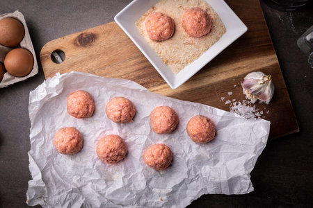 Raw homemade meatballs with pork on the kitchen table.