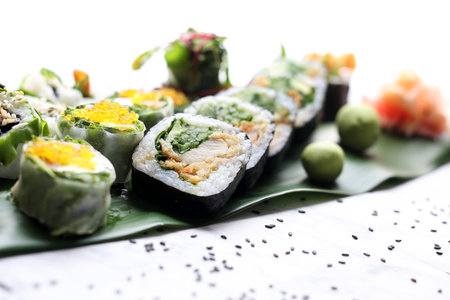 A set of a variety of colorful, fresh sushi served on a bamboo leaf.