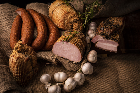 Traditionally smoked, homely sausage in composition with fresh garlic and herbs. Horizontal composition.の写真素材