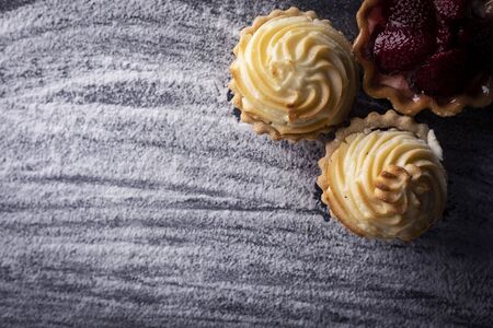 Sweet muffins with cream on a dark background.Composition with space for textの写真素材