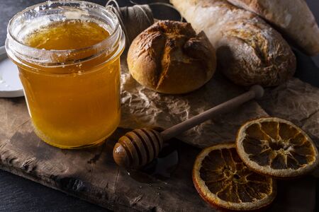 Sweet golden honey in composition with orange and bread.の写真素材