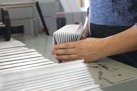 Work in the printing house. The employee packs the printed materials.