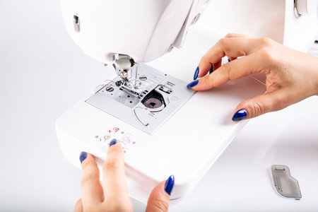 The woman sews on a sewing machine.