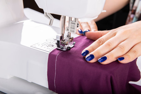 The woman sews on a sewing machine.