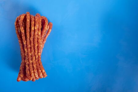 Smoked sausage, a composition of traditional dry, thin rural meats on a blue background. Regional food.の写真素材