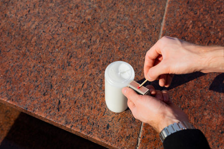 All Saints' Day celebration. Lighting a votive candle on a tombstone. The man lights a candle insert...