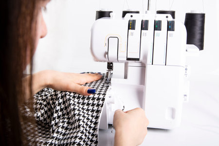 Overlock sewing. Sewing clothes on a sewing machine. Woman's upholstery