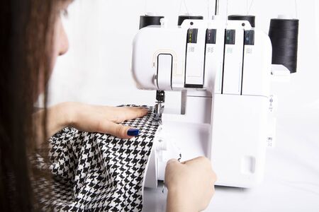 Overlock sewing. Sewing clothes on a sewing machine. Woman's upholsteryの写真素材