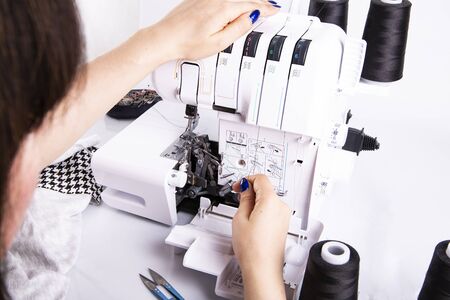 Overlock sewing. Sewing clothes on a sewing machine. Woman's upholsteryの写真素材