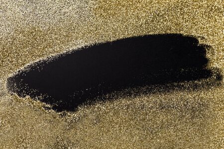 Shining, golden glitter on a black surface. Luxury texture brocade background for Christmas, new year, birthday, special occasions, with a space for text.の写真素材