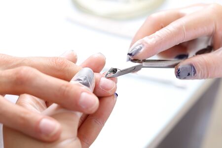 Hands beautifying treatment, woman in a beauty salon on a manicure procedure.の写真素材