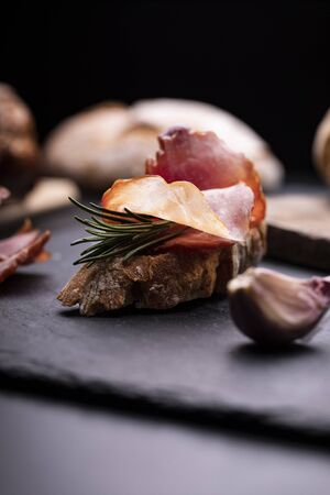 Sandwich made of freshly baked, crunchy bread with smoked, Krakowska dried sausage in composition with rosemary and garlic. Traditional cold cuts. Meat products.の写真素材