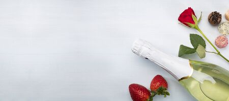 Red rose, strawberries, chocolates and champagne on a white background with a copyspace.の写真素材