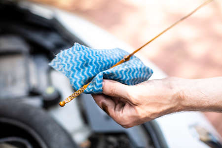 Checking car engine oil level under the hood of a car. Vehicle check-up.の写真素材