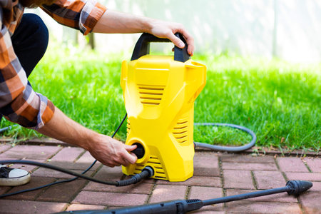 Using a compact pressure washer in the garden.