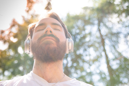 Man listening to the music on a headphones. Photo with a lens flares effect.