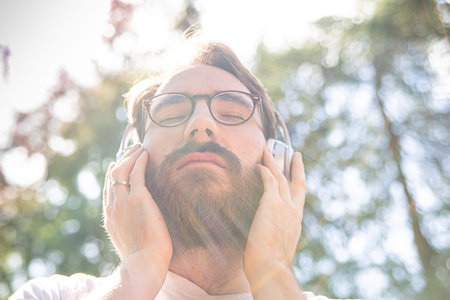 Man listening to the music on a headphones. Photo with a lens flares effect.