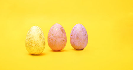Hand painted easter eggs on a yellow background, horizontal view. Easter decorations, wide banner...