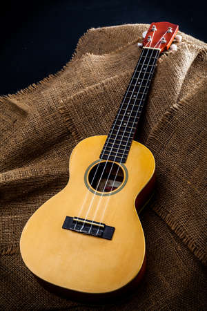 A ukulele on brown wooden background.の写真素材