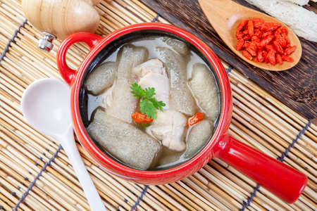Chicken soup with Chinese herbs and bamboo in a white bowl.の写真素材