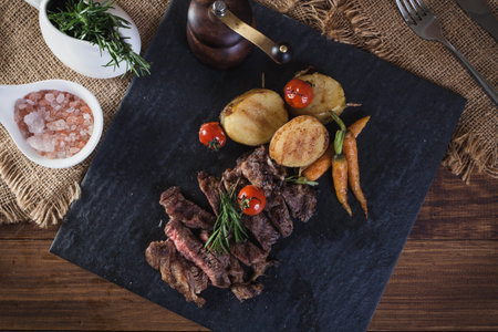 Beef steak with vegetables and spices on a cutting board