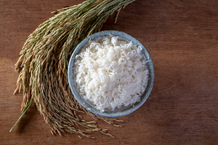 White rice (jasmine rice) in a sack on a wooden background