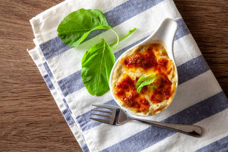 Baked spinach with cheese on a wooden backgroundの写真素材