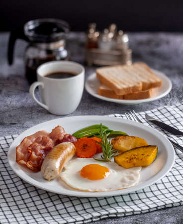 Delicious breakfast bacon, sausage, fried eggs, bread, coffeeの写真素材