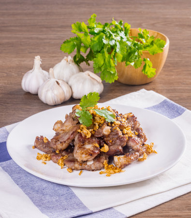 Garlic and pepper pork bones fried on a wooden tableの写真素材