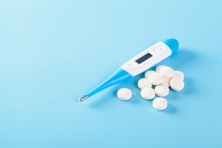 Clinical thermometer, white on a blue background showing heat fever