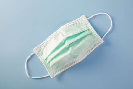 Mask with rubber ear straps. Typical 3-ply surgical mask to cover the mouth and nose. Procedure mask from bacteria. Protection concept.の写真素材