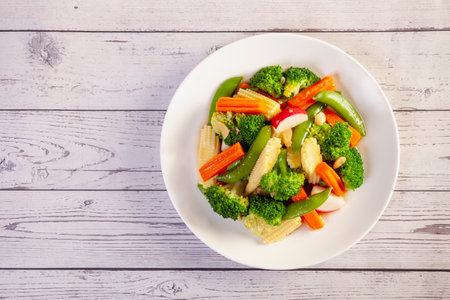 plate of stir fry vegetables on wooden tableの写真素材