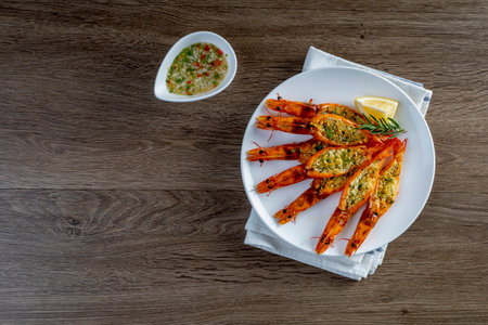 Grilled garlic butter prawns, in a plate on a wooden tableの写真素材