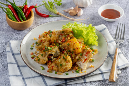 Fried sea bass with salt and pepper on the tableの写真素材