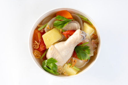 Chicken soup with potatoes, tomatoes, carrots, onions and vegetables.の写真素材
