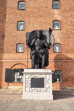 statue of Mary Thomas aka Queen Mary next to brick building 'Westindian storehouse', Copenhagen, Denmarkのeditorial素材