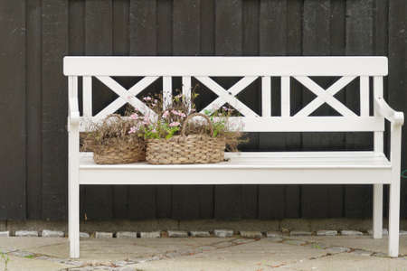 flower baskets on white bench - green wooden backgroundの写真素材