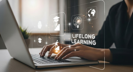 A person is typing on a laptop with "Lifelong Learning" concept overlaid, symbolizing continuous education and knowledge.の素材