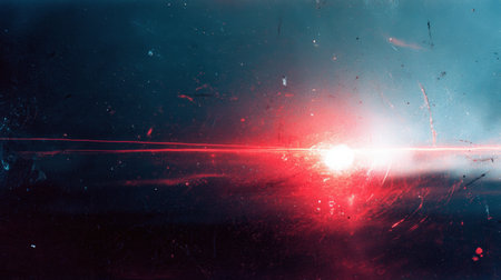 An abstract image featuring a bright red light burst against a dark, space-like background with scattered particles, creating a dynamic and energetic visual effect.の素材