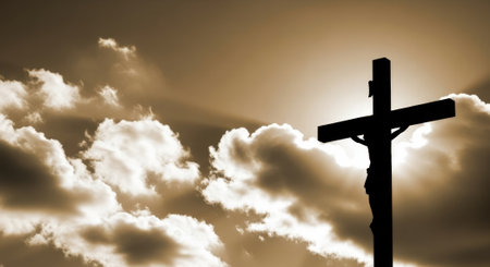 A powerful silhouette of Jesus Christ on the cross, set against a dramatic sky filled with clouds and a hint of sunlight.の素材