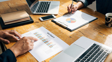 Businessman analyzing investment charts with laptop and mobile phone. Business concept.の素材